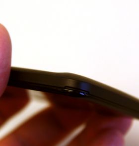 Telefonen har ikke utskiftbart batteri, men den har et stort bakdeksel likevel. Det åpnes ved å dra i denne fliken her.