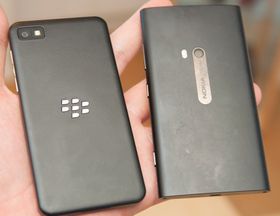 Slik ser baksiden på BlackBerry Z10 ut ved siden av en Nokia Lumia 920. Bakdekselet er avtagbart og skjuler batteri, plass for SIM-kort og minnekort.