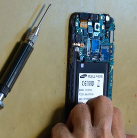 Teknikeren går raskt i gang med å demontere telefonen.