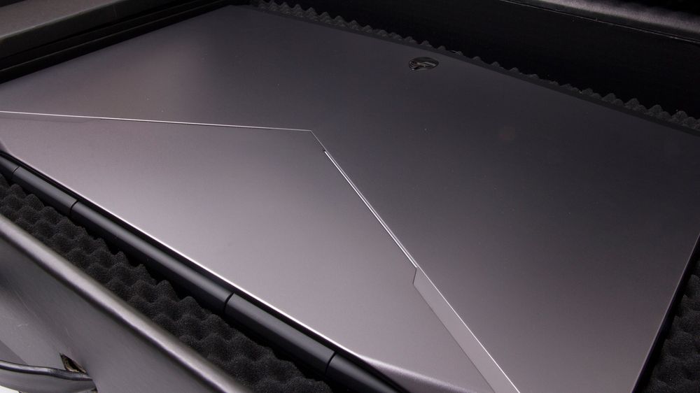 Et skikkelig maskulint topplokk. Materialet er i mørk sølvgrå plast, med en Alienware-logo i krom til å krone det hele.