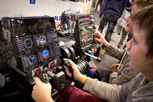 Ivrige deltakere tester en flysimulator fra Mad Catz.