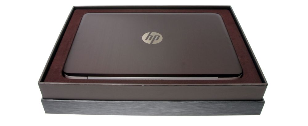 Pen og gullende ren, med HP-logoen i skinnende metall på den trøffelbrune aluminiumbaksiden.