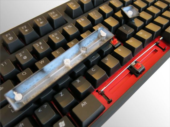 Cherry MX Red med Costar-festemekanisme på tastehettene, gjenkjenbart med metallstangen som ligger på langs under mellomromstasten.