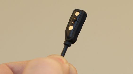 En magnet holder kabelen på plass ved lading.