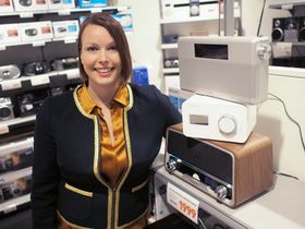 Kommunikasjonssjef Marte Ottemo i Elekstronikkbrnasjen poserer sammen med en annen av salgsvinnerne i 2013, nemlig DAB-radioen.