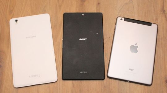 Baksiden på Xperia Z3 Tablet Compact er dørgende kjedelig, uten at det egentlig gjør så mye. Til venstre Samaung Galaxy Teb S5 8.4, til høyre iPad Mini 2.