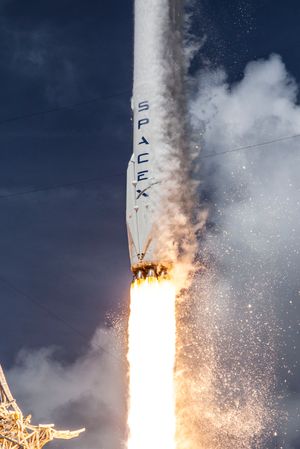 Falcon 9-raketten under oppskytning. På siden kan du se landingsbenene som felles ut når raketten går inn for landing.