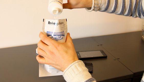 Middelet helles i posen, før telefonen legges oppi.
