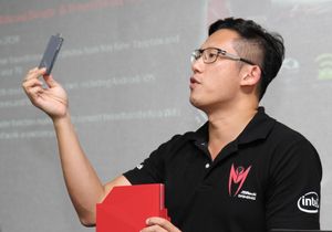 Markedssjef Chris Lee i ASRock viser frem den kombinerte reiseruteren og Miracast-donglen.