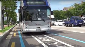 Sørkoreansk elbuss stopper på et ladefelt ved bussholdeplassen.