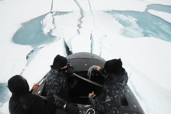 Mannskap på SSN 21 står i tårnet etter å ha brutt opp gjennom isen på Nordpolen.  
