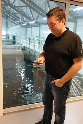 Daglig leder Erik Daaland ved Lerøy Midnor Belsvika viser hvordan han justerer foring til fisken via mobiltelefonen. Det er en stor lettelse å kunne kjøre dette på stedet i stedet for å måtte gjøre det fra kontrollrommet. 