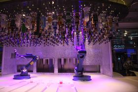 To Kuka-roboter serverer drinker. Men det går seint.