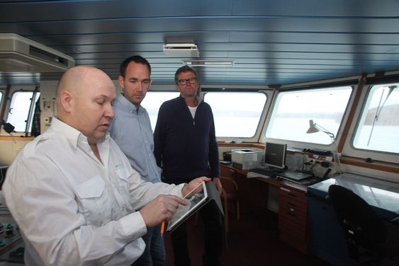 Kaptein Torleif Bakken på Bastø II med Rex ruteplanlegger på en iPad. Kaptein og sikkerhetsrådgiver Gisle Stava i Bastø Fosen har bidratt til utviklingen av Rex som Geir Fagerhus (bakerst) i Marsec-XL står for.