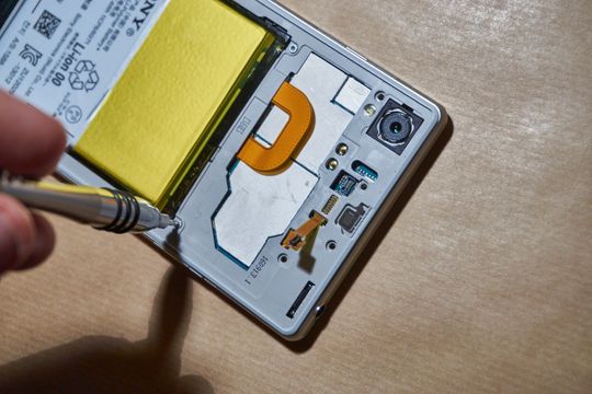 Batteriet kobles på, og rammen skrus inn.