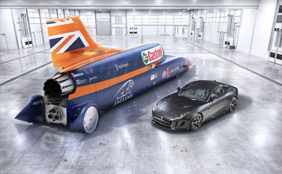 Fullskalamodellen av Bloodhound (den ekte vare er i ferd med å bygges nå) sammen med en Jaguar F-type. Den supersoniske bilen kommer til å veie over sju tonn og den er 14 meter lang.  