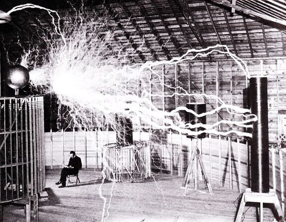 Bilde av en assistent i laboratoriet i Colorado Springs. Bildet viser Teslas «forsterkende sender» (en variant av Teslaspolen) som genererer millioner av volt. Lysbuen er nesten syv meter lang. Teslas egne notater identifiserer bildet som en multieksponering. (Kilde: Wikipedia)