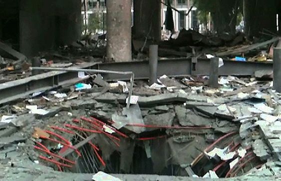 Bilde klippet fra en video som viser krateret / hullet i bakken under bilen med bomben som eksploderte utenfor høyblokka i regjeringskvartalet fredag. Bildet viser situasjonen bare minutter etter eksplosjonen. 