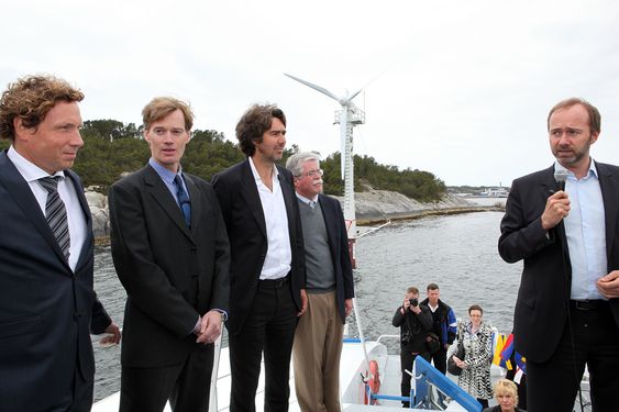 Daglig leder i Sway, Michal Forland (f.v.), oppfinneren Eystein Borgen og Jon Erik Borgen fra Inocean lytter til Trond Giskes åpningstale - med Sway-turbinen i bakgrunnen.