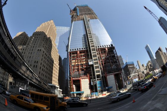 1WTC sett fra inngangen til World Financial Center i West Street. Den mye omtalte betongbasen til 1WTC skulle egentlig dekkes med prismatisk glass, men det lot seg ikke gjøre. Bak til venstre skimtes glassfasaden til 7WTC. Til høyre ser man trærne i minneparken.