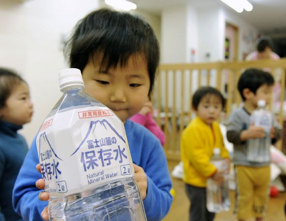 Et barn med en flaske vann i en barnehage i Tokyo. Nivået av radioaktivt jod i springvannet i byen er dobbelt så høyt som det som regnes som trygt for små barn.