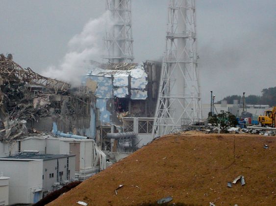 I GRUS: Reaktor 4 (i midten) og reaktor 3 (til venstre) ved Fukushima Daiichi kjernekraftverk i Japan. Bilde tatt 15. mars 2011.