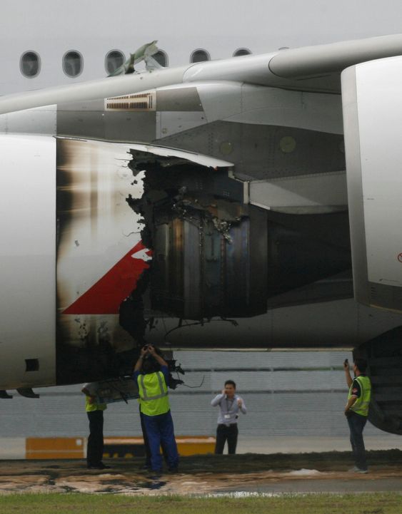 Technicians look at the damaged engine of a Qantas Airways A380 passenger plane flight QF32 after it was forced to make an emergency landing at Changi airport in Singapore November 4, 2010. The Airbus A380 landed safely in Singapore on Thursday after running into engine trouble, one of the most serious incidents for the world's largest passenger plane in its three years of commercial flight.  REUTERS/David Loh (SINGAPORE - Tags: TRANSPORT DISASTER BUSINESS) Qantas A380