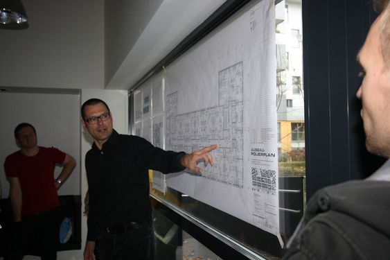 Bildetekst: Arkitekt Eckerhart Loidolt forklarer en gruppe norske arkitekter layouten til en studentbolig i Wien.
