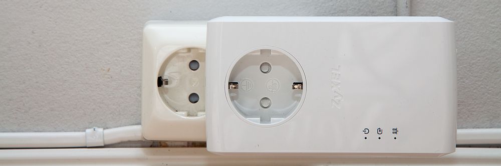 Adapteren er ganske stor, og blokkerer delvis stikkontakten ved siden av.