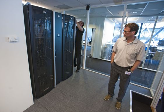 Datarommet bak møterommet i HPs «Enterprise Technology Center» innholder to rack med bladservere og lagring. Mellom rackene er et smalere skap: kjølemodulen. Det lysende feltet midt på kjølemodulen viser driftstemperaturen. Gaute Ledang mekker, Jan Fredrik Gunvaldsen står foran.