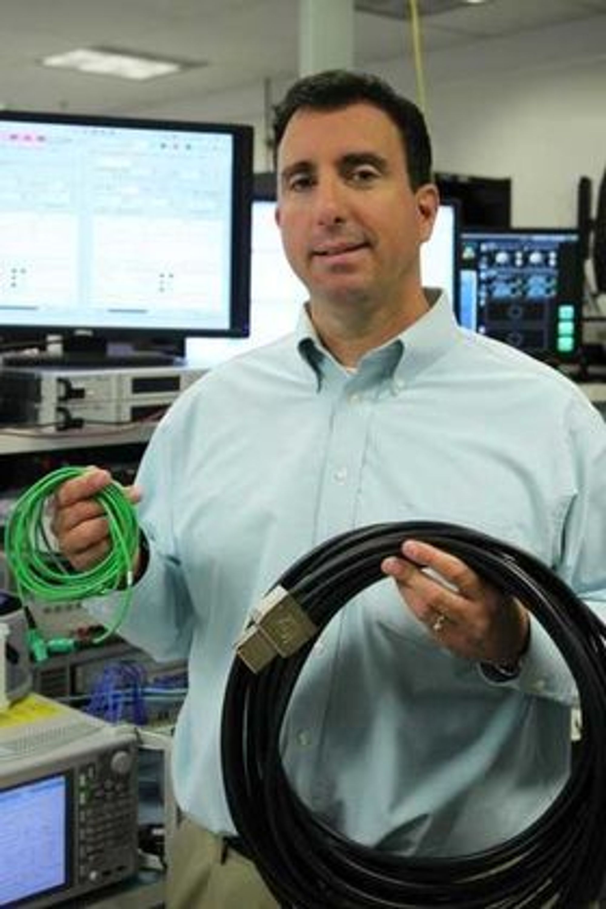 Mario Paniccia  med en 1,6 terabit per sekund MXC-kabel (grønn) og en kobberbasert 128 gigabit per sekund PCI Express-kabel.