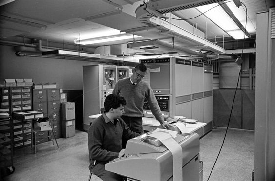 Tom Kurtz og studenten Michael Busch tester den nye GE-225-datamaskinen ved Dartmouth College i 1964. Busch var med i studentgruppen som lagde det omtalte systemet for tidsdeling av datamaskinen. 