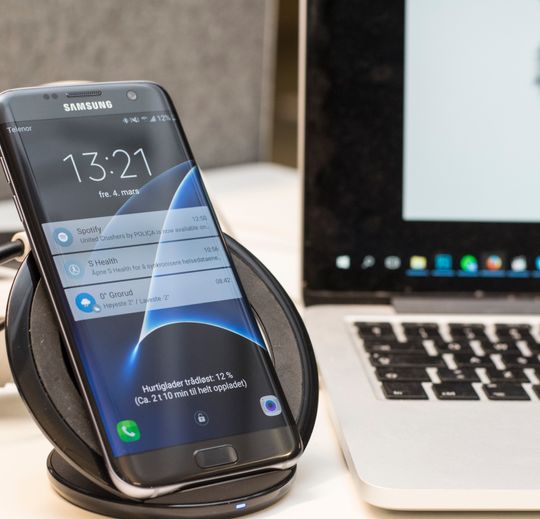 Galaxy S7 Edge hurtiglader ved siden av PC-en.