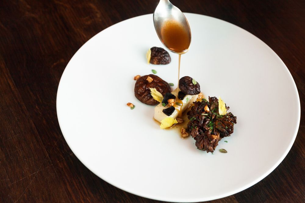 Sellerirot bakt i tørrmodnet oksefett, fritert maitak, grillet shitake, puffet byggryn og svart hvitløk.