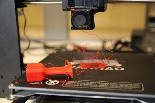 EPIC FAIL: På grunn av sammentrekning har øretelefon-holderen i ABS-filament vridd seg løs fra støtteplata, som fortsatt sitter godt fast i skriverplata.