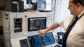 Scott Plimley viser fram den norske operatørkonsollen inne på avionikk-integrasjonstestanlegget, med det nyintegrerte systemet for å finne mobiltelefoner.