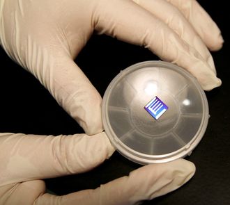 Under utvikling: Her er en solcelle som NTNU-forskerne skal teste. Der den er blå, er det lagt på solcelle-tynnfilmer. Fargen skyldes at tykkelsen på den øverste filmen (50 nm) skaper interferens­effekter på samme måte som et tynt lag av olje på vann. «E»-formen er topp-elektroden hvor strømmen trekkes ut når solcella testes.