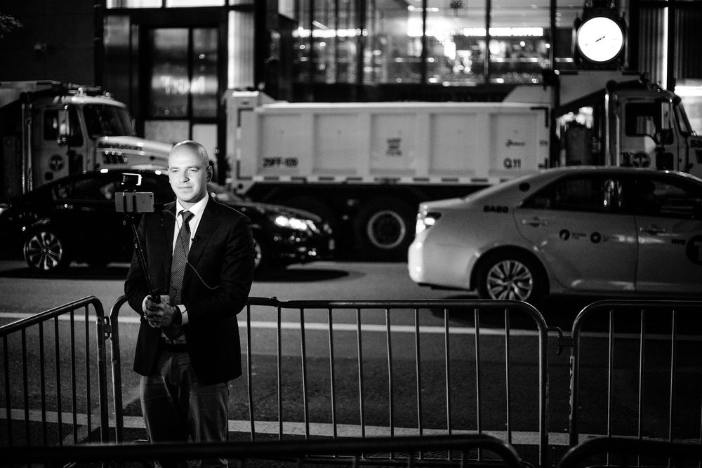 TRUMP TOWER, 8. NOVEMBER 2016 - KL 19.37: Utenfor Trump Tower, noen få kvartaler fra valgvaken, så sto en enslig reporter med selfiestang og mobilkamera inngjerdet i pressepiten. I bakgrunnen ser vi lastebiler fylt med sand, for å beskytte mot eventuelle angrep. De første meldingene om at Trump faktisk kunne vinne Florida begynte å komme inn.