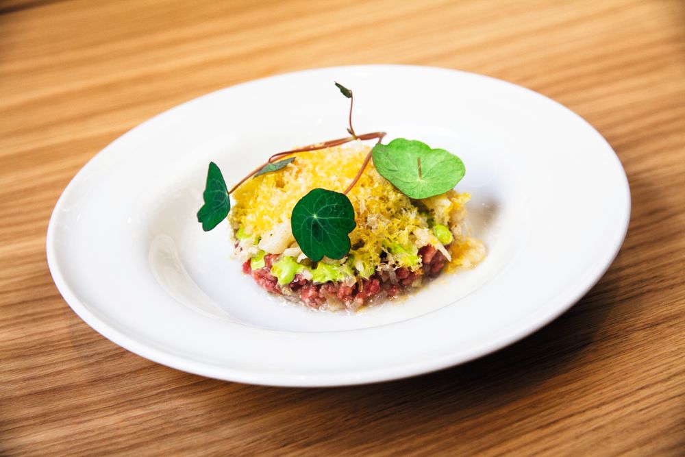 Tartar servert med røkt blomkarsemajones, gravet eggeplomme, kamskjell, puffet svinesvor.