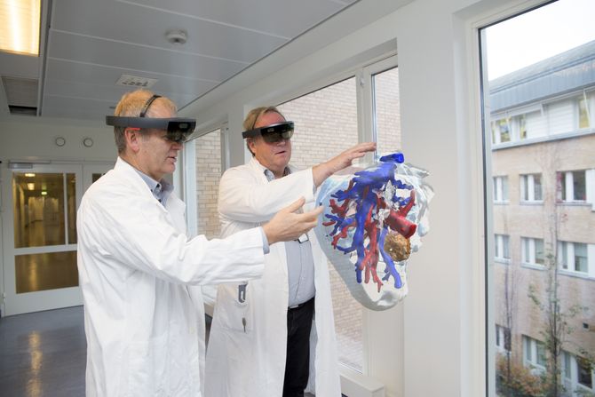Leder for teknologisk forskning ved Intervensjonssenteret på Oslo universitetssykehus, Ole Jakob Elle og kirurg Bjørn Edwin demonstrerer HoloLens-teknologien.