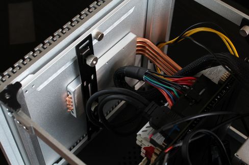 Etter å først ha montert kjøleløsningen på CPU-en, kan det aktuelle sidepanelet settes på og brukes som en stor kjøleribbe. Her er varmerørsløsningen festet med en av kabinettbrakettene. Merk glipen mellom rørløsningen og panelet, her er det den varmeledende puta som gjør at det ikke blir god nok kontakt.