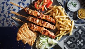 SOUVLAKI: Denne retten er laget av svinekjøtt på grillspyd og serveres med pitabrød, grønnsaker, pommes frites og tzatziki.