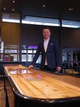 NYOPPUSSET: Den nye hotelldirektøren står her ved siden av shuffleboardet i baren rett ved lobbyen. – Dette skal være et koselig og fleksibelt hotell. Det har blit t kjempefint etter oppussingen, sier han.