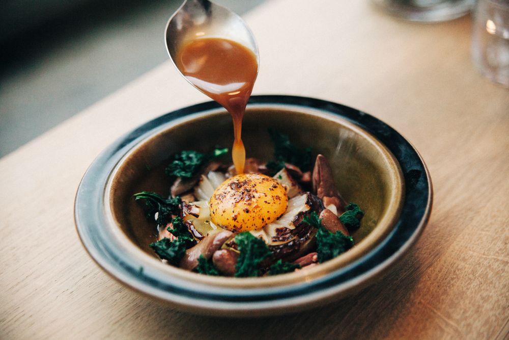 Løksuppe med kyllinghjerte, grønnkål og syltet eggeplomme.