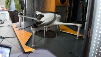 En robotarm bytter dronens batteri og kamerautstyr.