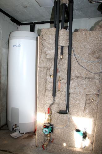 Ved siden av varmtvannsberederen er det installert en isolert tank på 300 liter. Den fylles med vann som er forvarmet gjennom rør støpt inn i masseovnen. Varmtvannsberederen får vann inn som allerede holder godt over 30 grader.