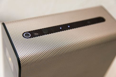 Den ser ut som en høyttaler, men lager altfor liten lyd for sin størrelse. Her er det også bygget inn en mobiltelefon med middels ytelse og en projektor med IR-sensor for berøringer. På toppen finnes de fysiske knappene den har; av/på og berøringssensorer for volum opp og ned.