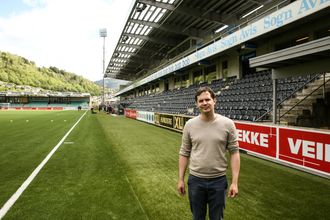 SYNERGIER: Daglig leder i Rocketfarm Aslak Os på kunstgresset på Fosshaugane der A-laget er i ferd med å avslutte treningen i bakgrunnen. Synergiene i miljøet er spesielle.