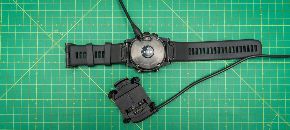 Fenix 5-klokkene har fått en betydelig slankere ladekabel enn den gamle «krybba» fra Fenix 3-serien (nederst på bildet over). Fint når du er på reise, men nå blir det langt fra like enkelt å lade klokka og bruke den samtidig. Med det gamle systemet kunne du koble til en batteribank, legge klokka i toppen av sekken eller rundt sykkelstyret, og fortsette målingene omtrent som før.