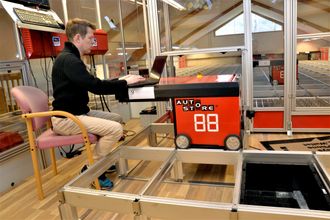 AutoStore, bedriften som utvikler robotiserte plukklagersystemer, er solgt ut av Hatteland-gruppen, men hovedvirksomheten blir i Åmsosen. Her er softwareutvikler Dan Ove Nilsen i arbeid med en av robotene.